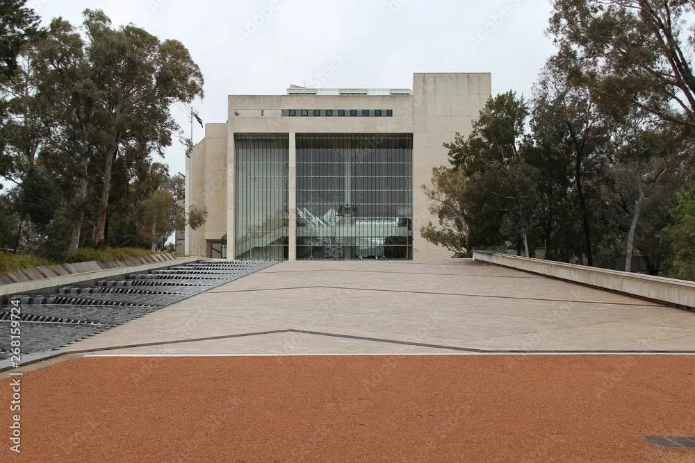 High Court of Australia building, Canberra, with reflecting pool and landscaping.