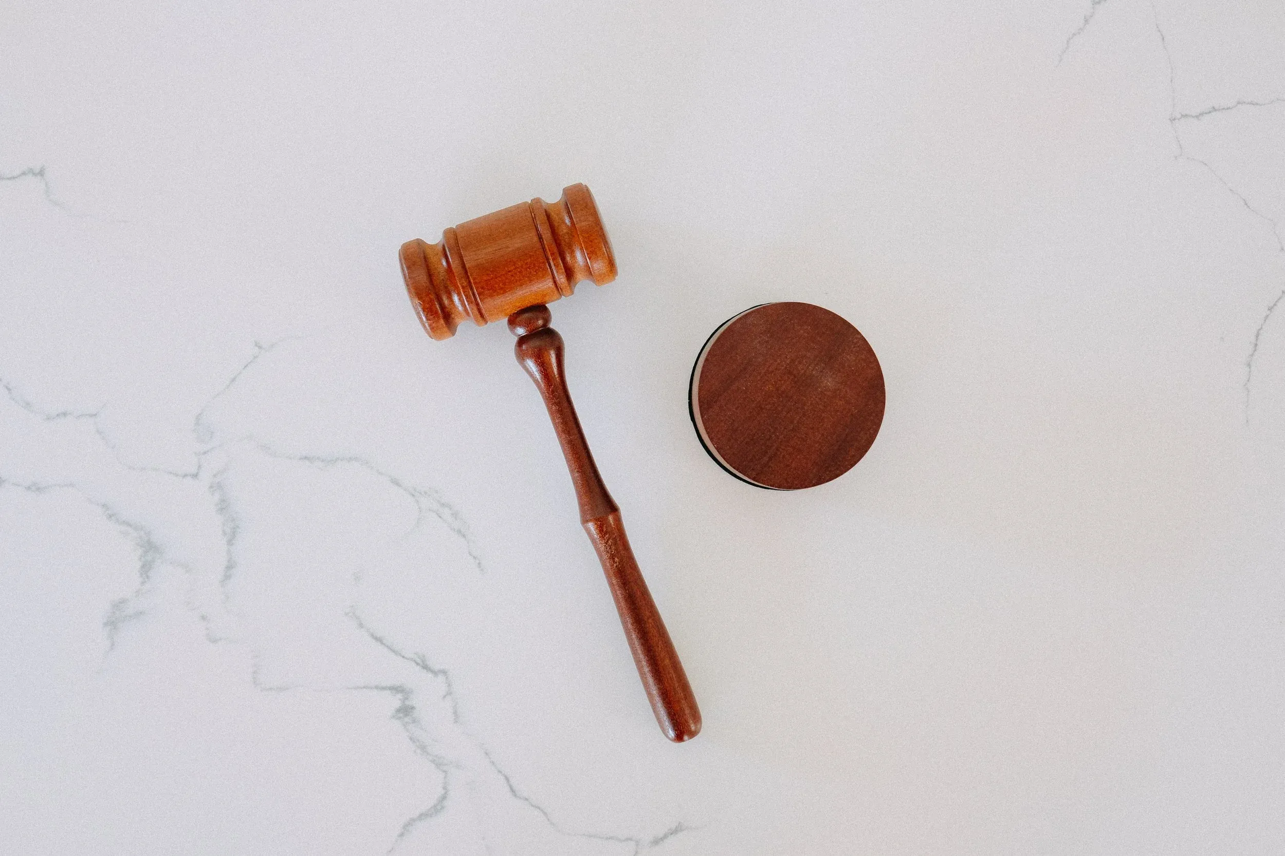 Wooden gavel and sound block on marble surface