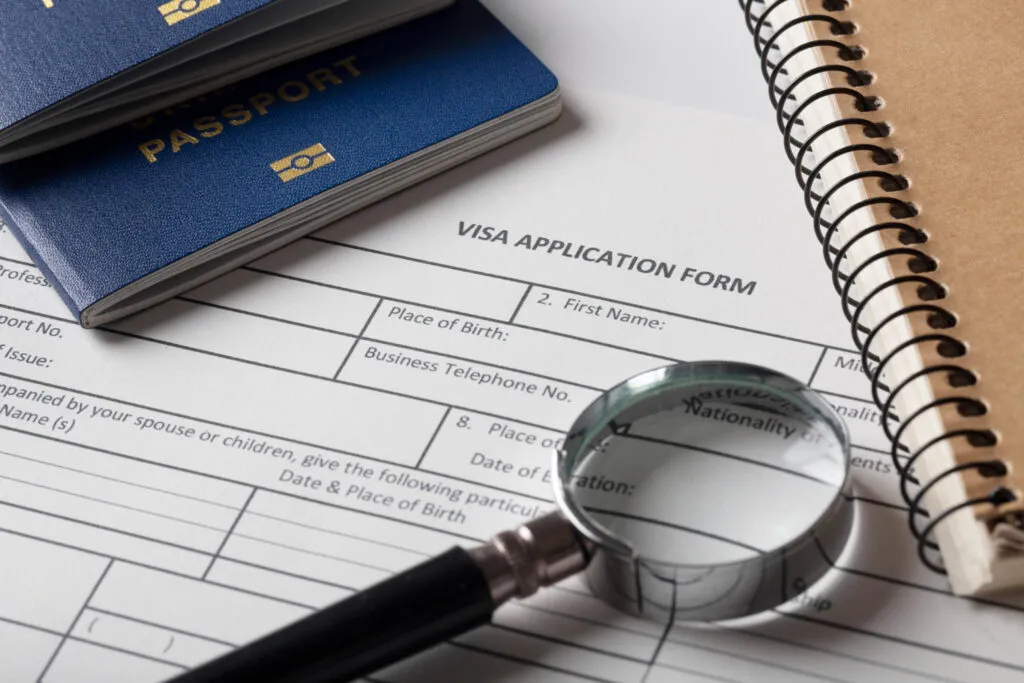 Visa application form with passports and magnifying glass.