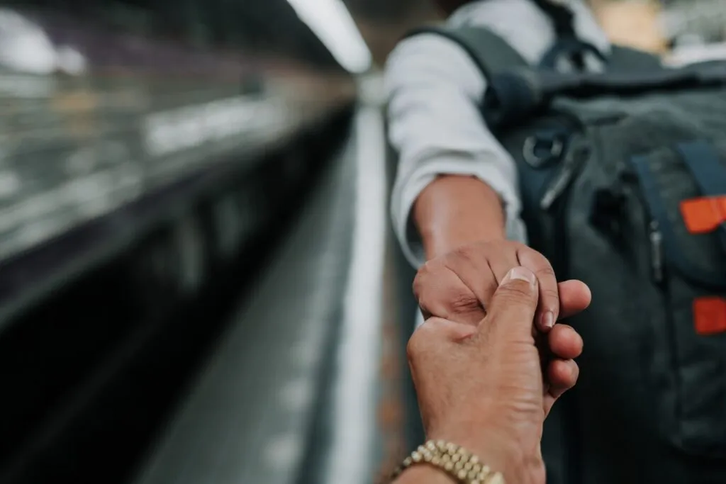 Two hands holding each other, symbolizing support and hope for immigration.