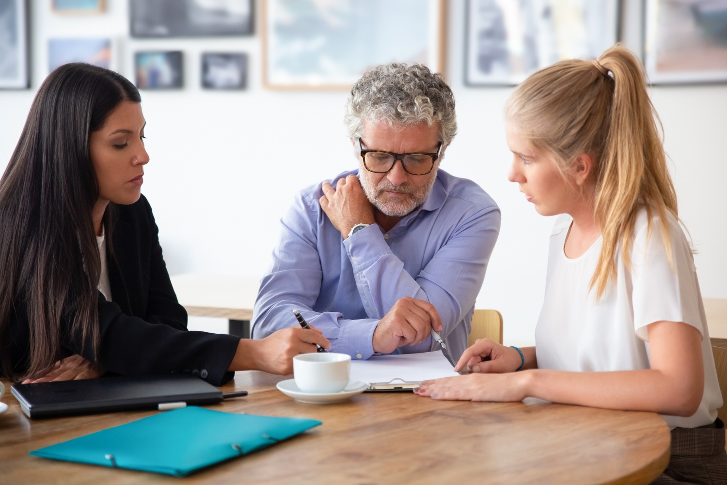 Family law mediation session: Lawyer, man, and young woman reviewing documents.