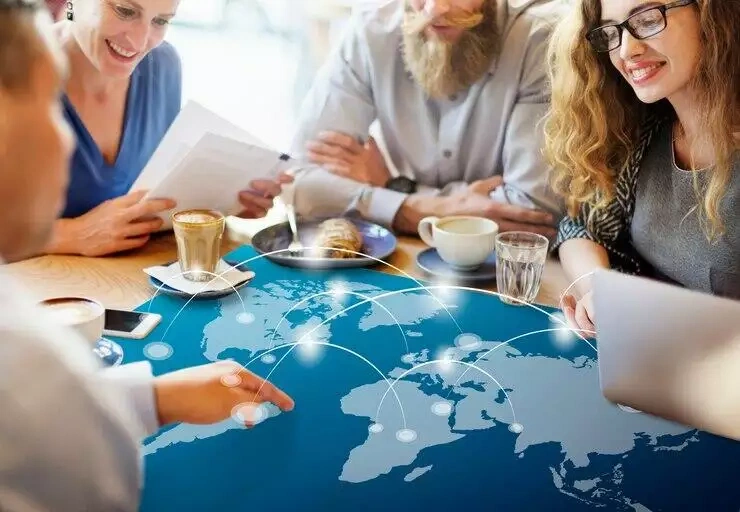 People collaborating around a table with a world map showing global connections.