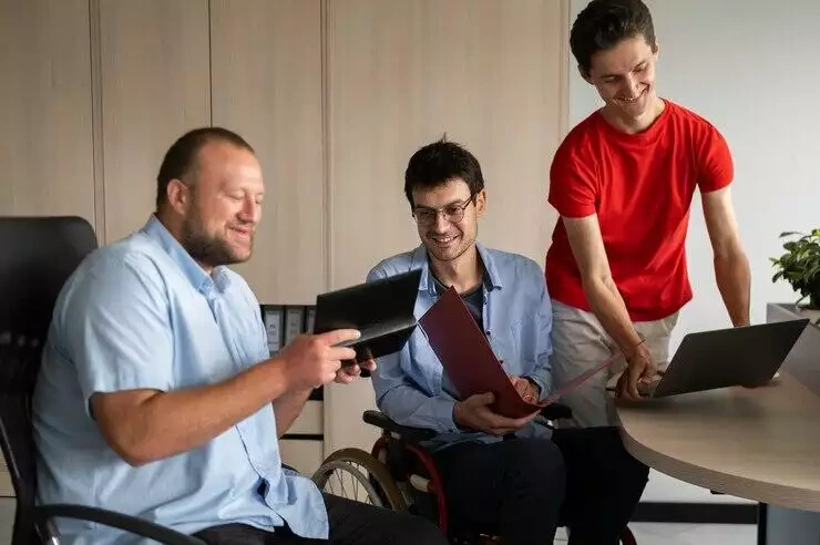 Three men reviewing documents and a laptop, discussing ACNC governance.