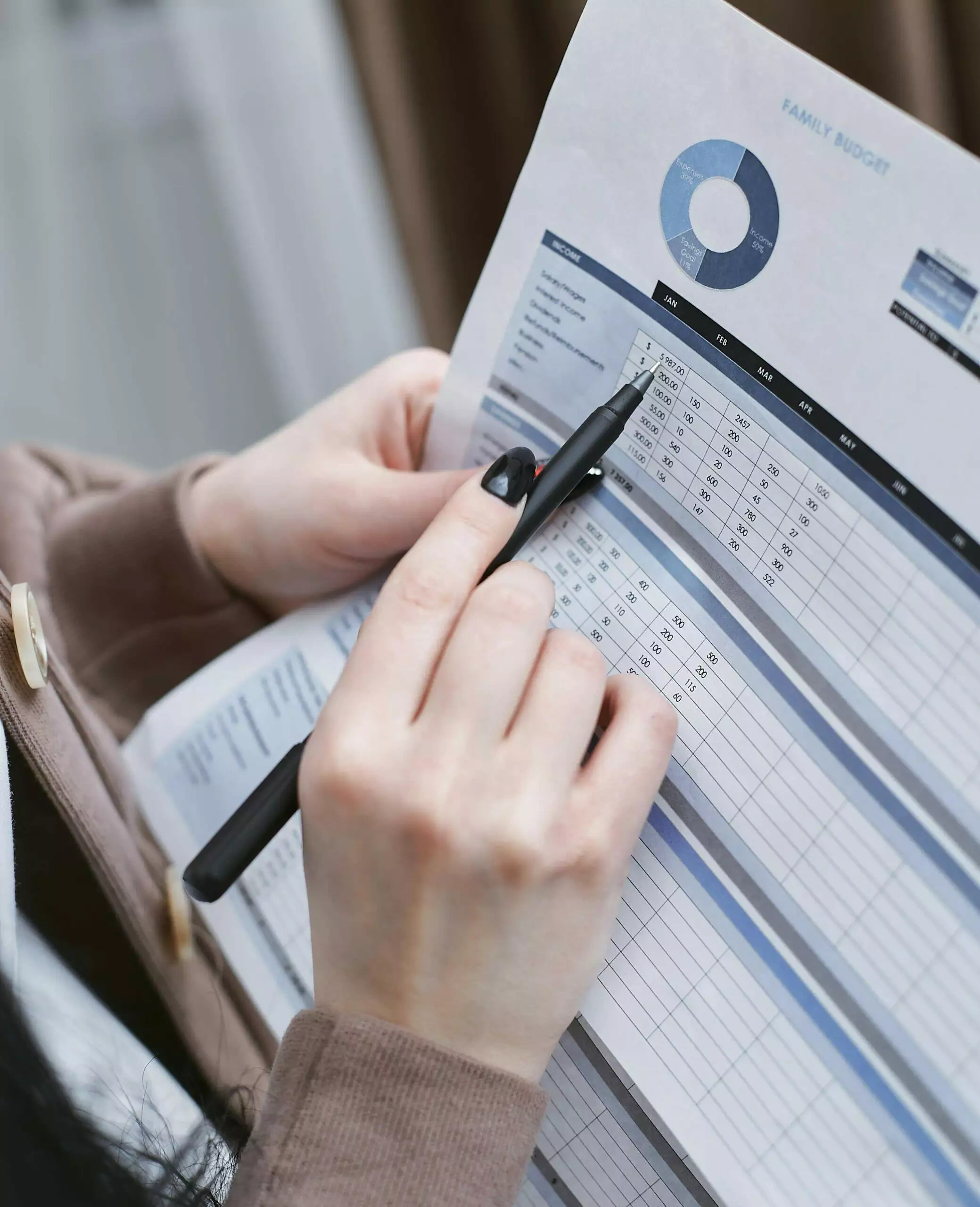 Close-up of hands reviewing a family budget document, highlighting financial planning and budgeting concepts relevant to ACNC and ASIC compliance for not-for-profits.