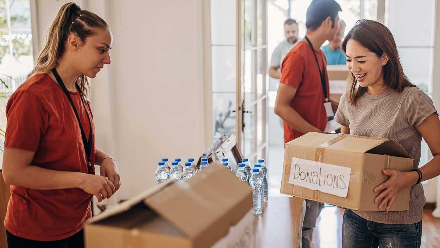 Volunteers sorting donations at a not-for-profit organization in Australia. Box labeled 
