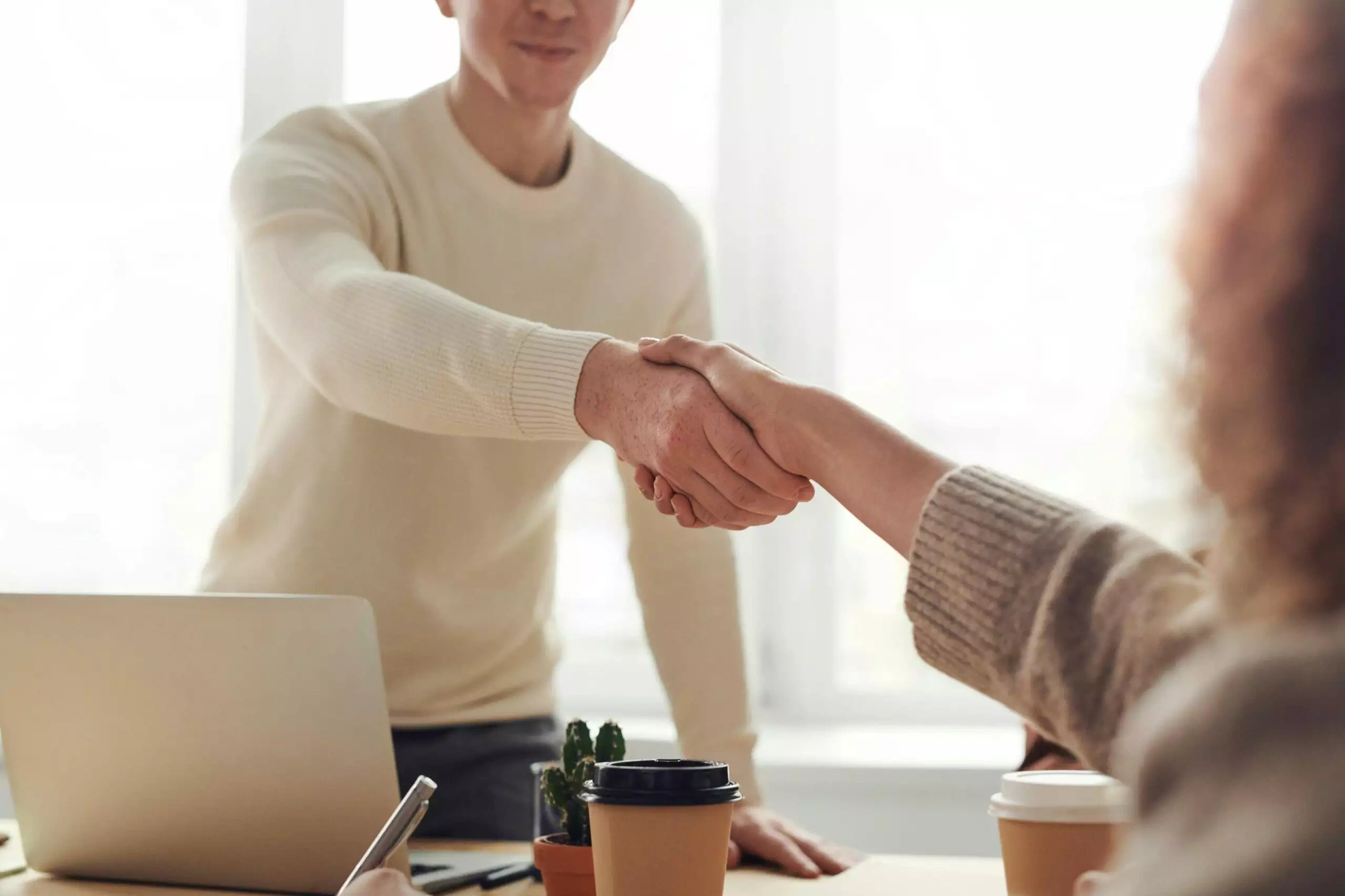 Business people shaking hands, signifying a contract agreement or termination.