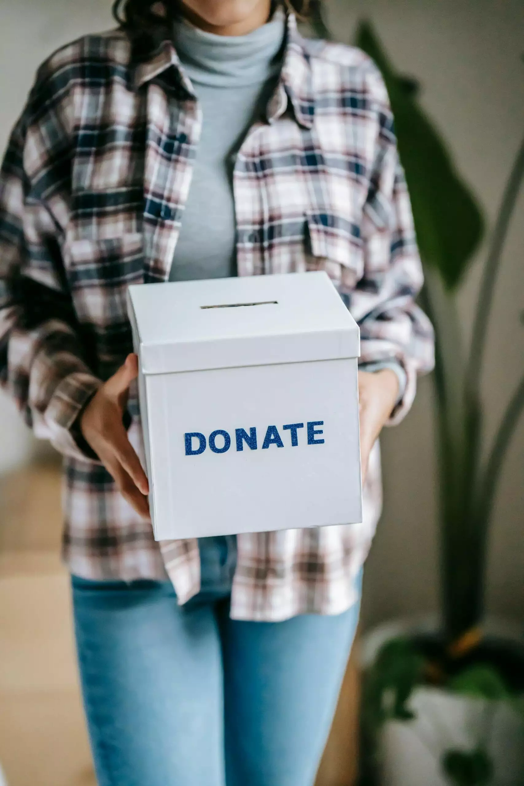 Person holding a donation box labeled