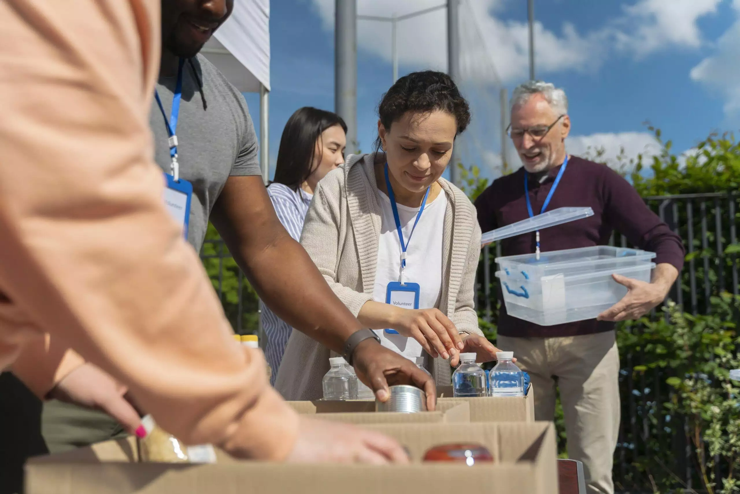 Volunteers sorting donations at a charity event. One volunteer's name tag reads