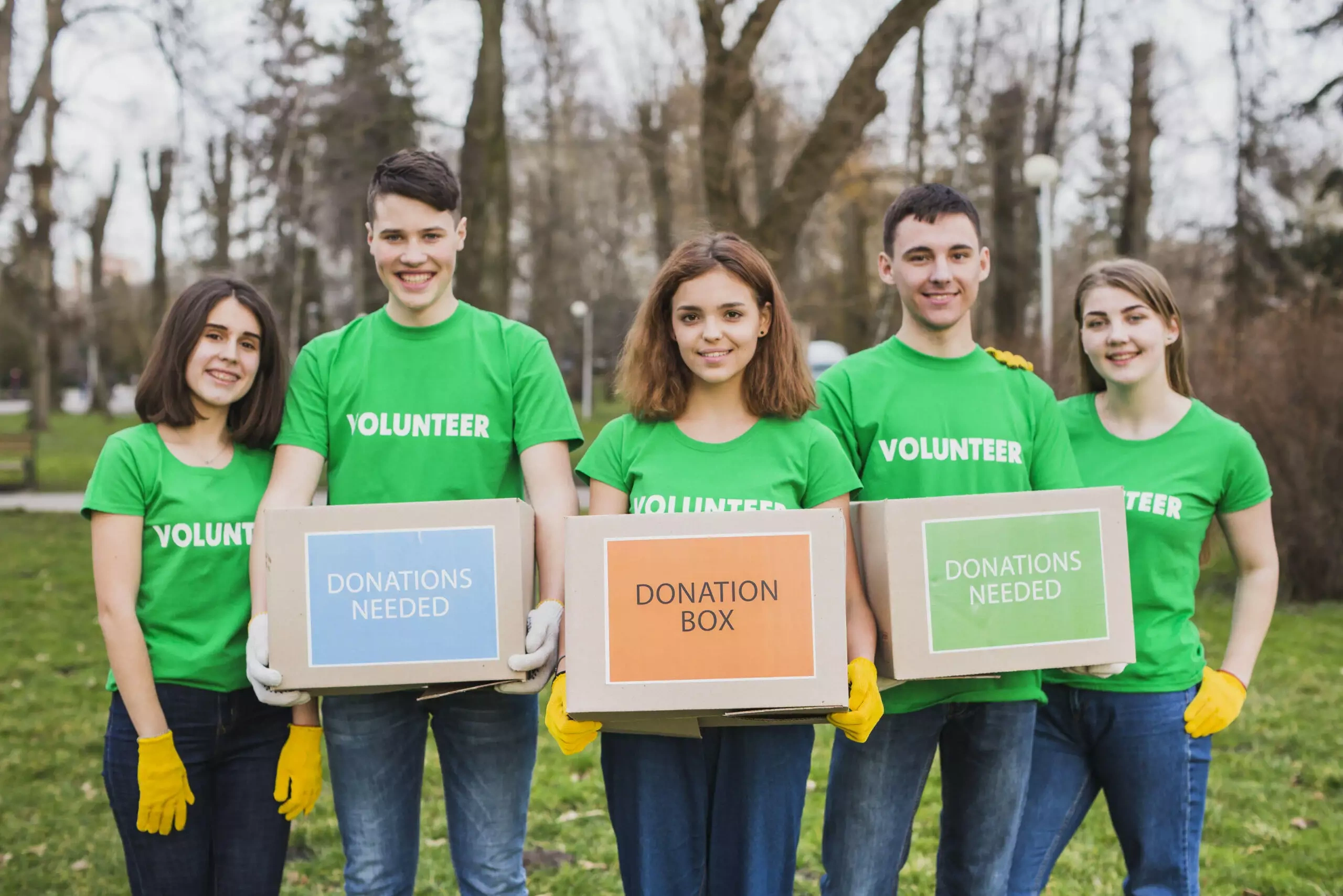 Five young volunteers holding donation boxes.