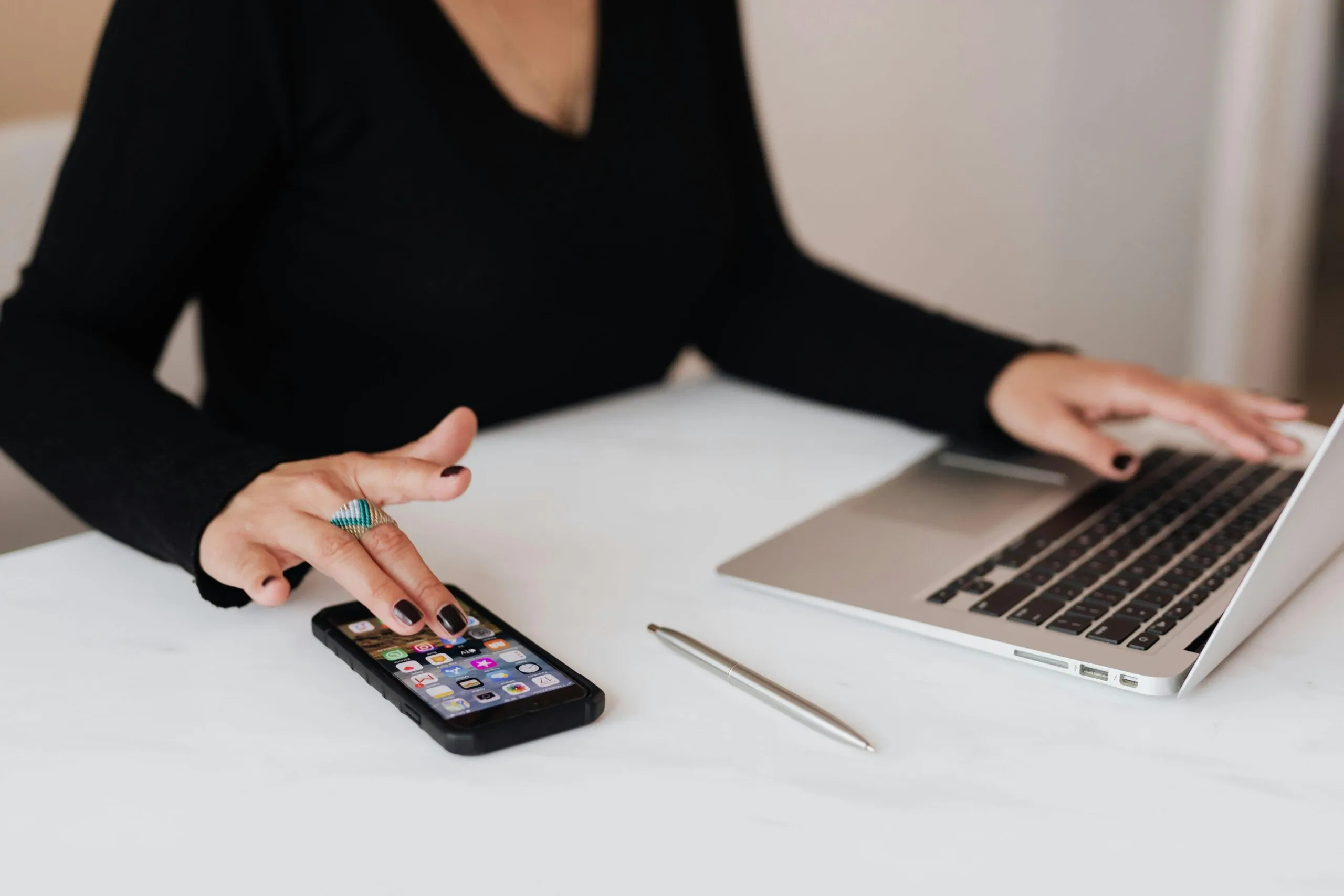 Person using laptop and smartphone for ACNC data tasks.