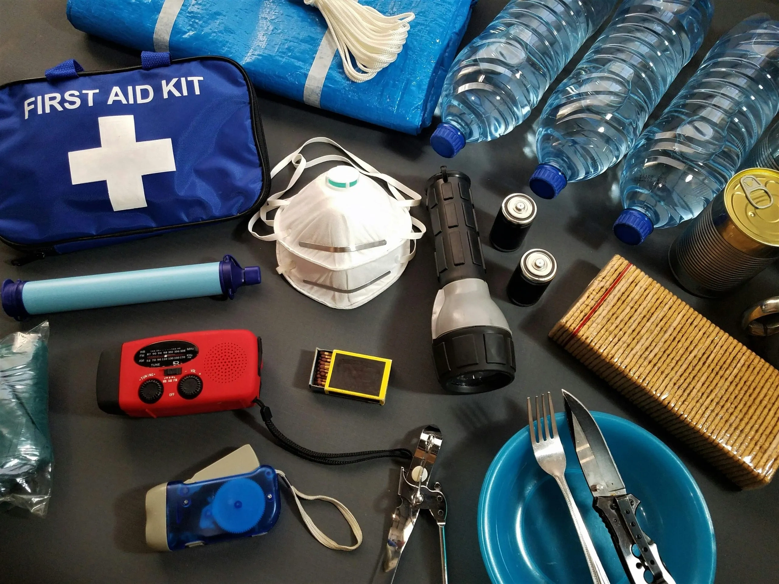 Emergency preparedness kit with first aid, water, radio, and food.