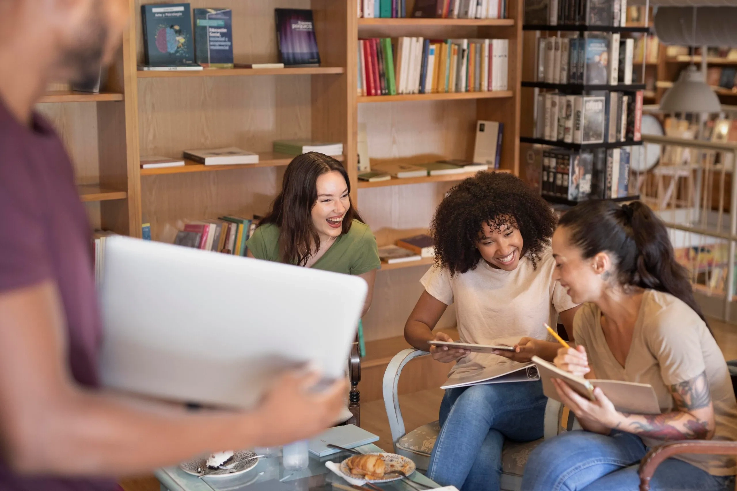 Charity board members collaborating and laughing together in a library setting, discussing managing conflicts of interest.