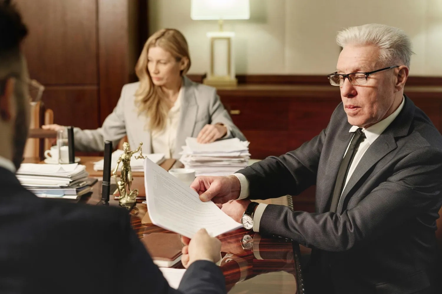 Lawyers reviewing documents, possibly related to PBI status defense after the