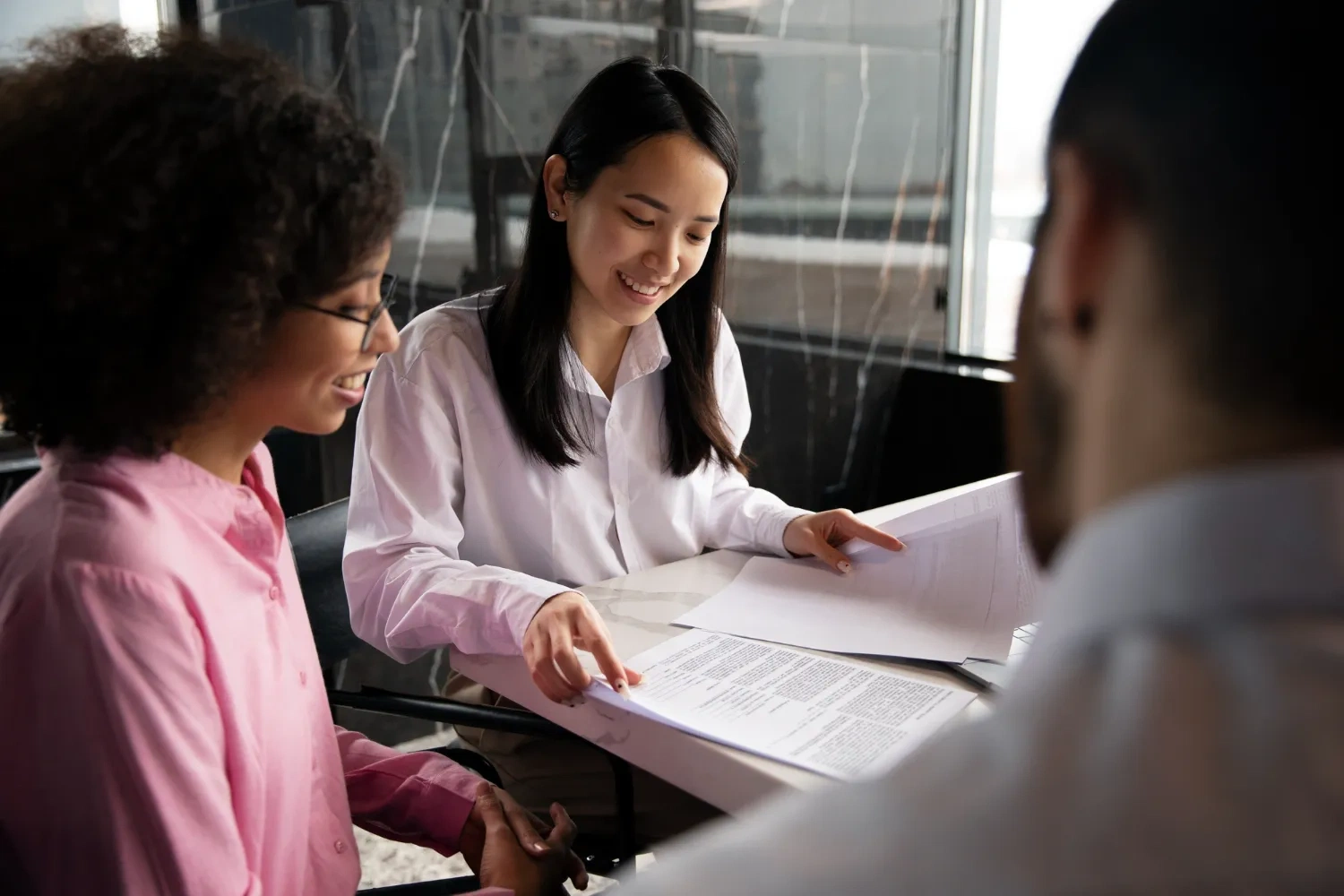 Two women review documents at a table, possibly related to DGR status.