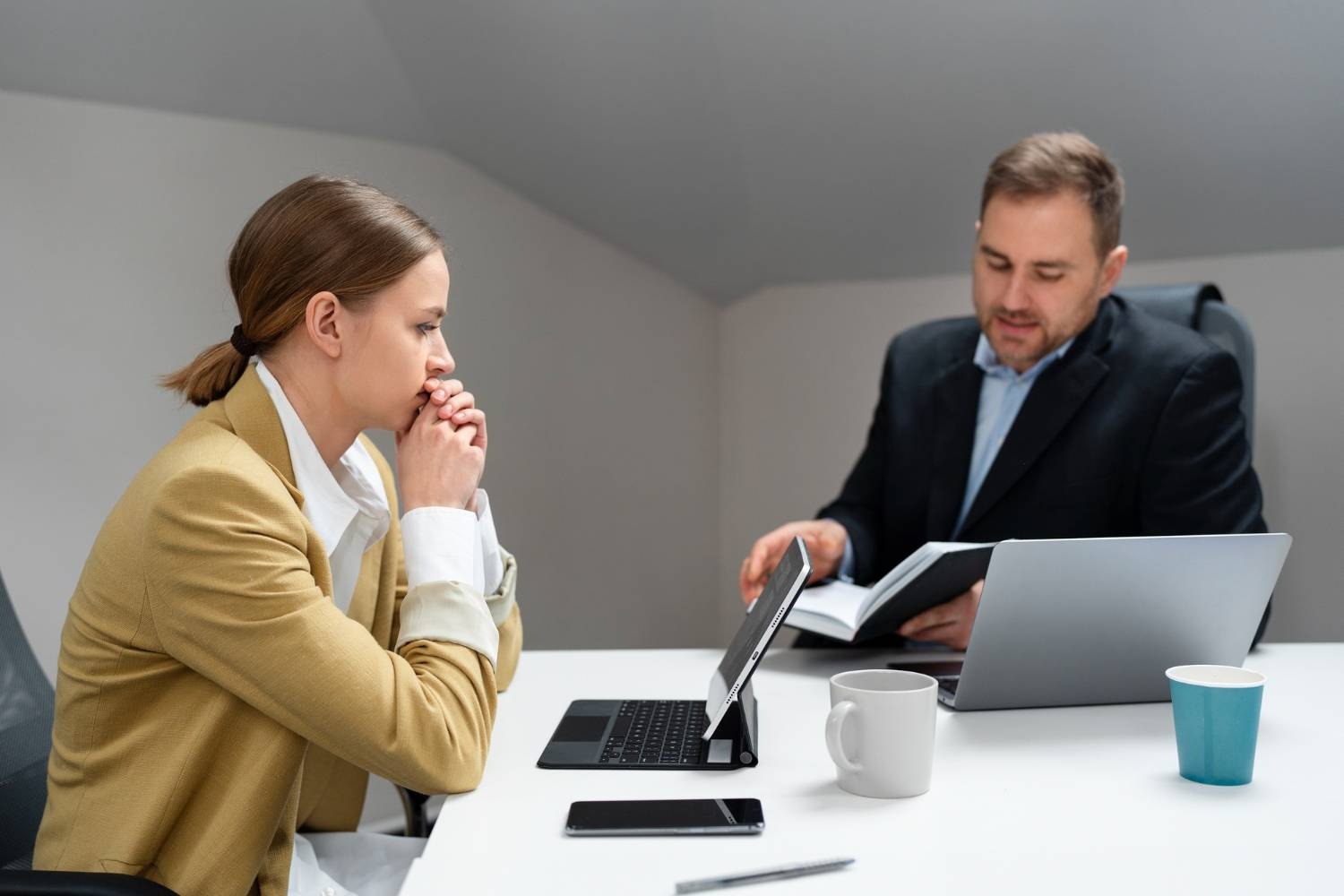 Concerned woman at a meeting with a man reviewing documents, possibly discussing managed services agreements.