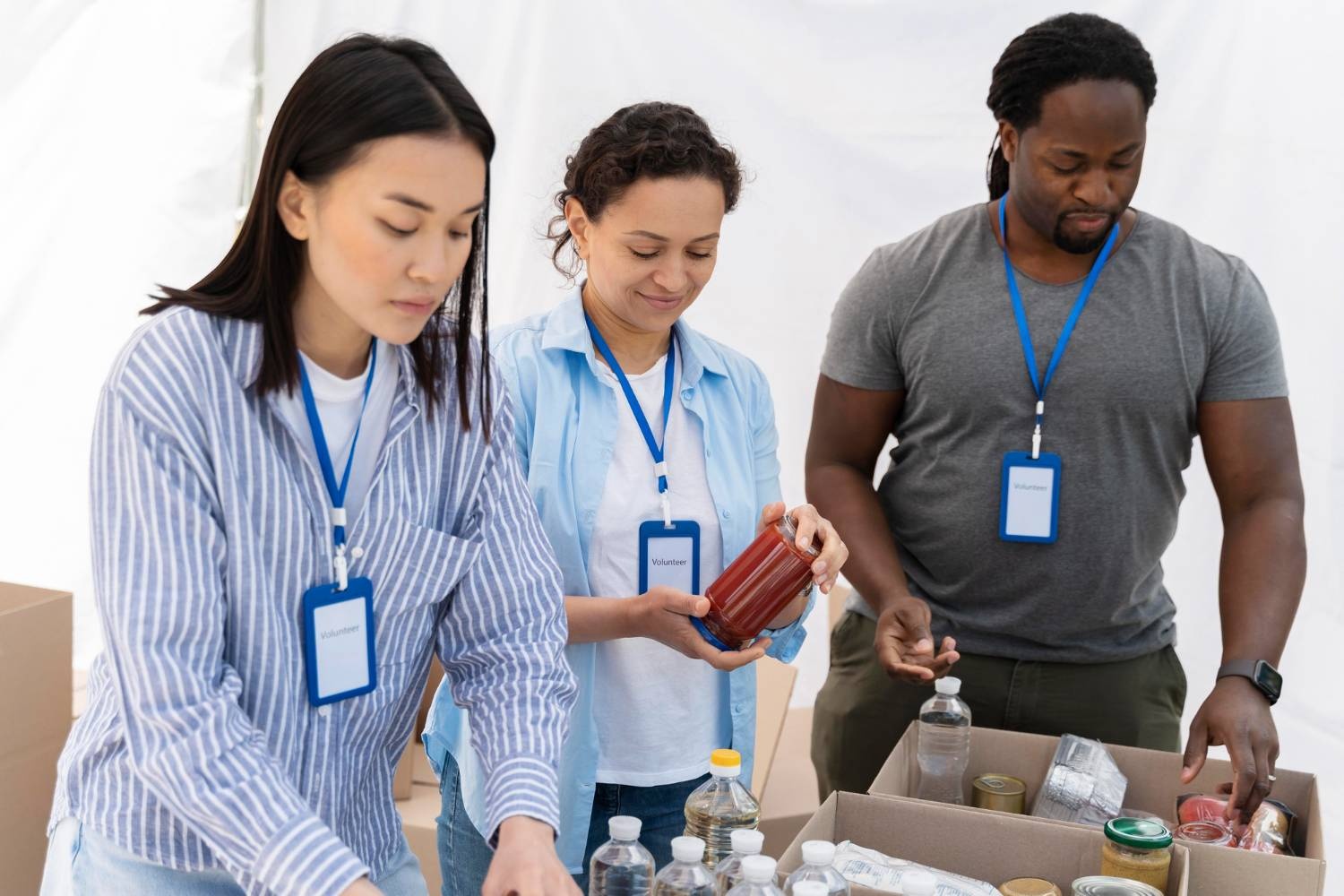 Volunteers packing food donations into boxes, supporting charity governance.