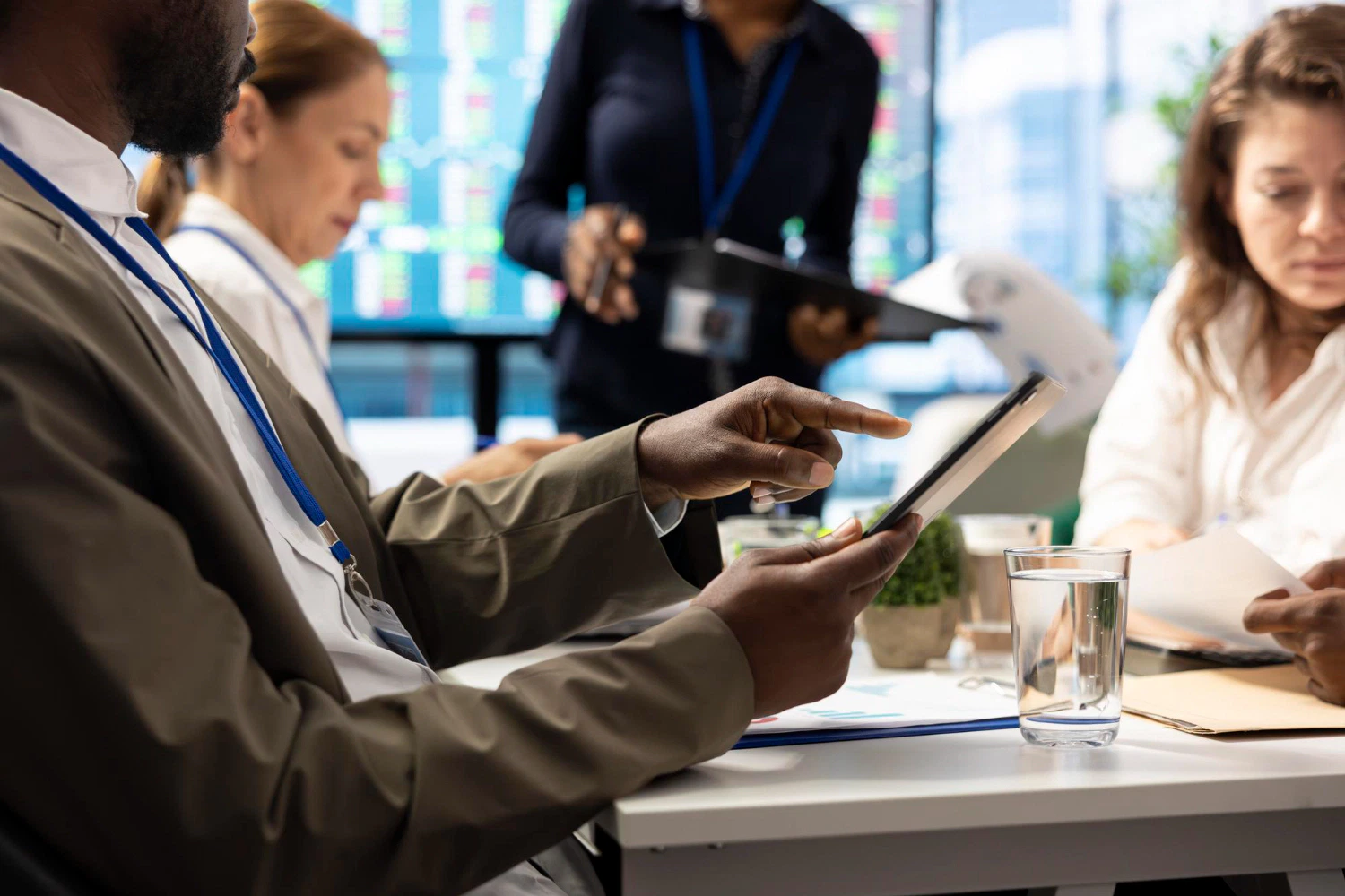 Business meeting with diverse team members reviewing data on a tablet.