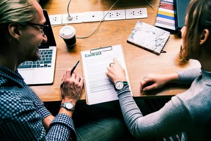 Two people review a NSW off-the-plan contract.