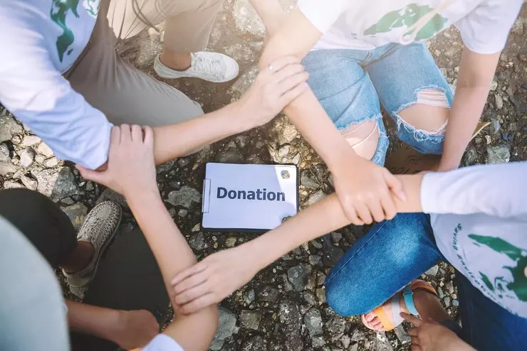 Team of volunteers holding hands around a