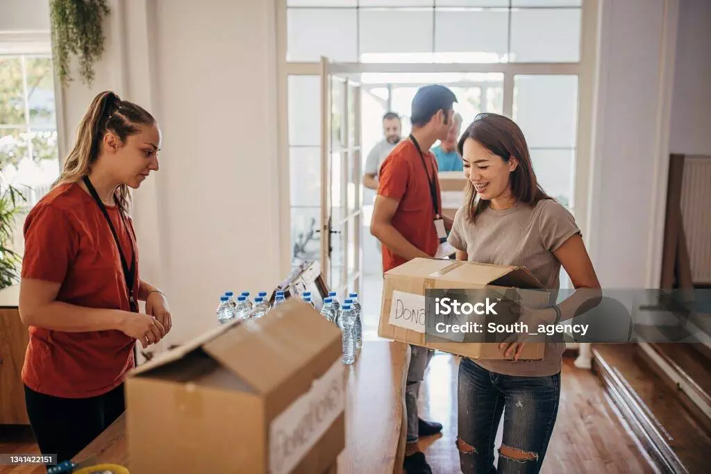Volunteers sorting donations at a charity. Boxes labeled