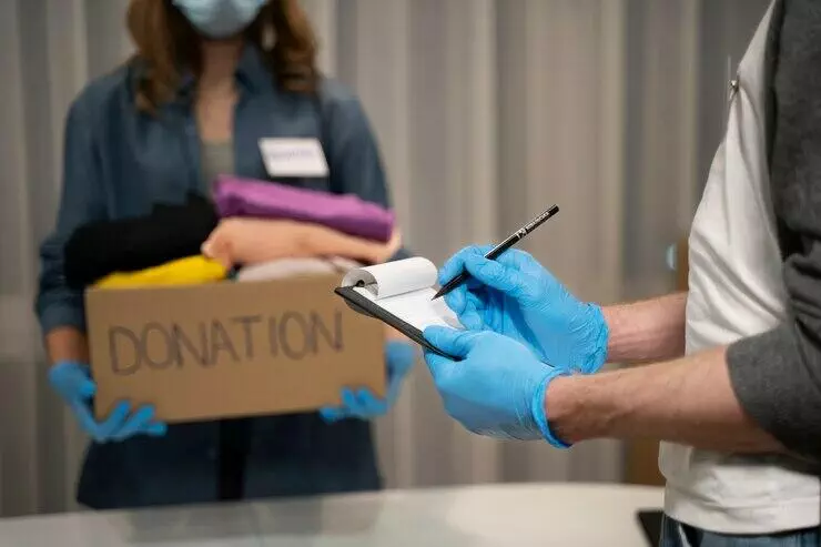 Volunteer recording donation details, ensuring ACNC compliance for charity board processes.