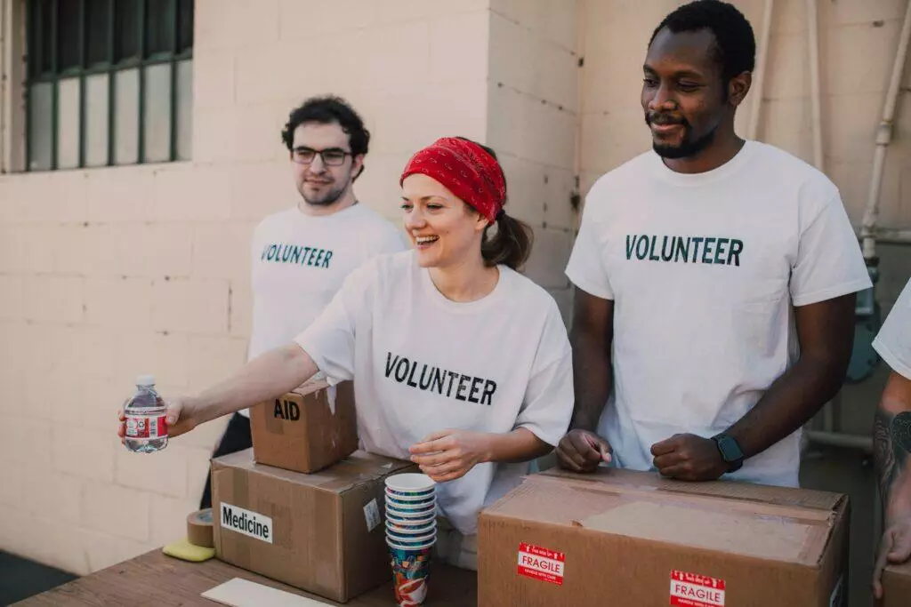 Volunteers sorting donations at a charity. Boxes labeled 