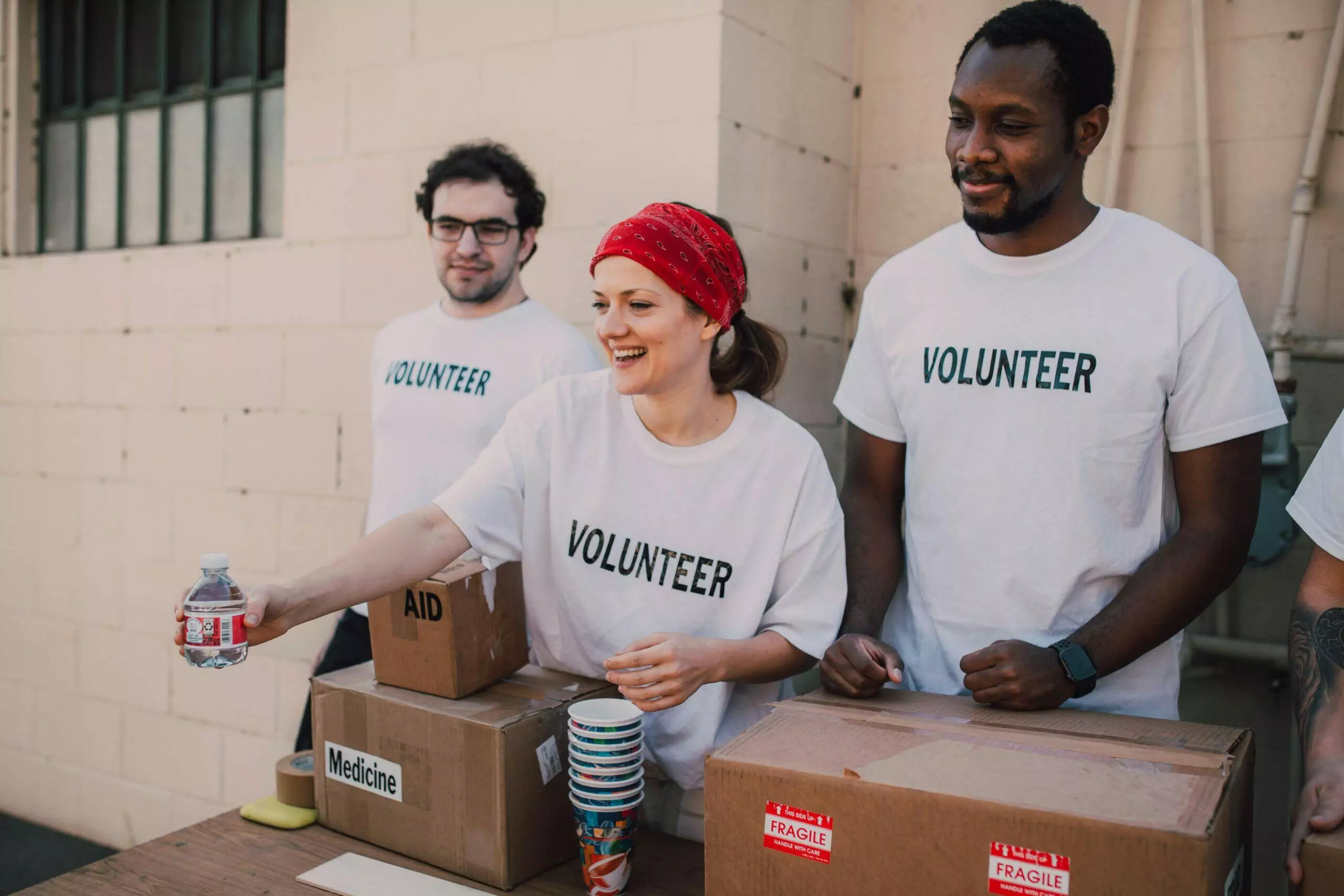 Volunteers sorting donations at a charity. Boxes labeled
