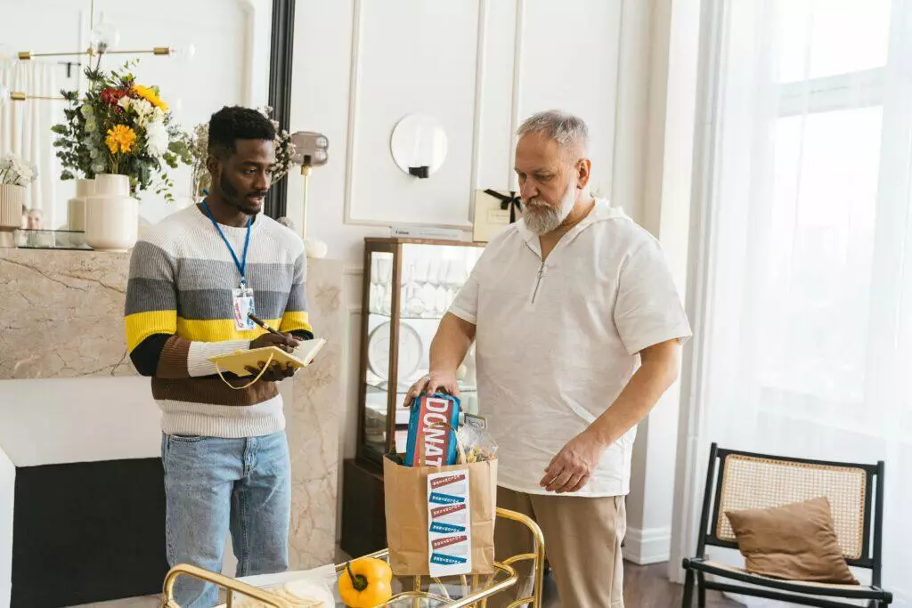 Two men reviewing a donation of food at a charity. 