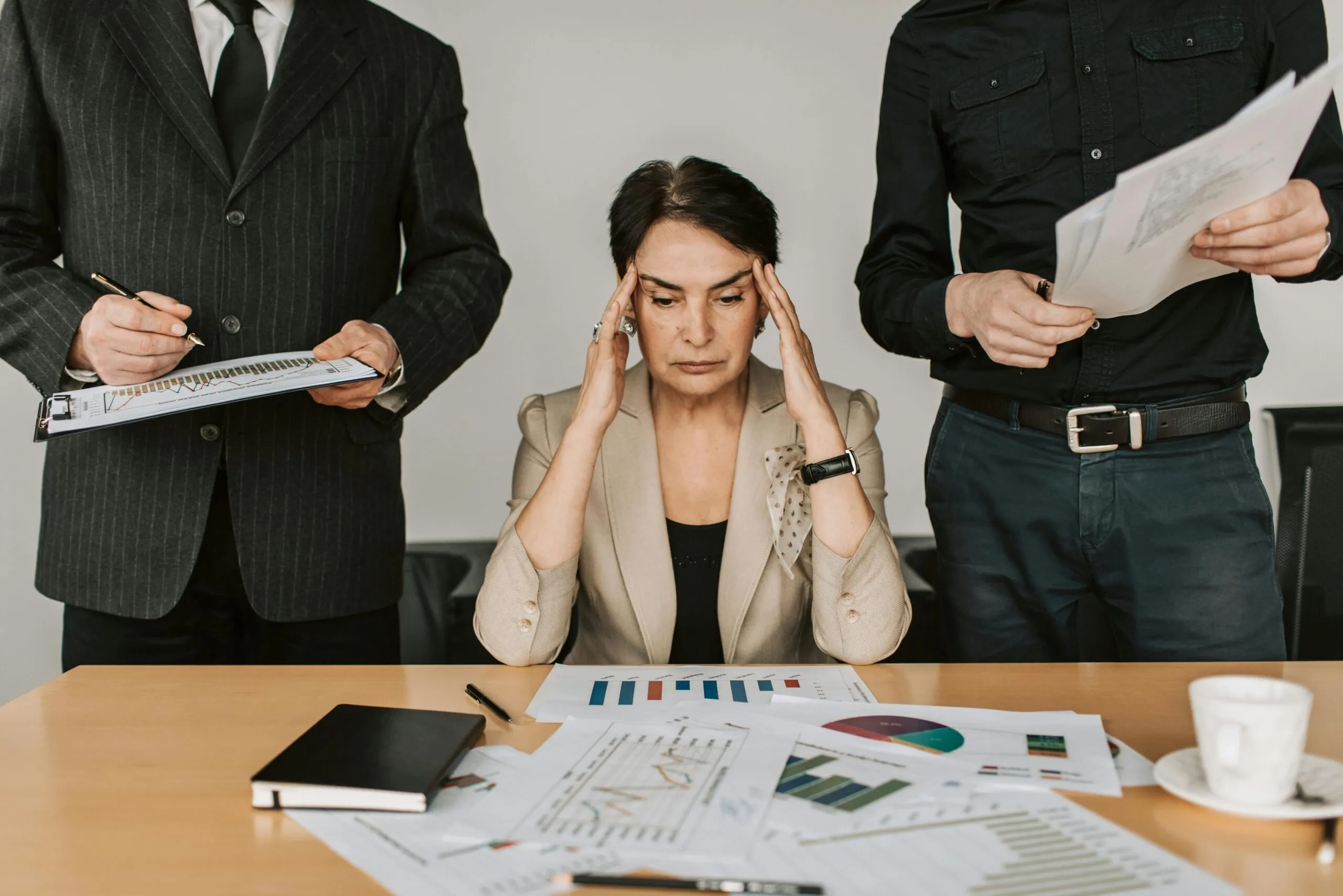 Stressed businesswoman in meeting, reviewing documents. Business planning and emergency recovery.